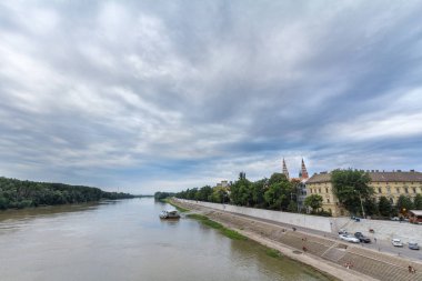 Szeged, Macaristan - 4 Temmuz 2018: Tisza Nehri, ışığa doğru günbatımı bulutlu yaz öğleden sonra sırasında sırasında görülen bir vurguyla Segedin Katedrali üzerinde görüldü Szeged şehir merkezi