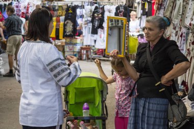 Lviv, Ukrayna - 18 Ağustos 2015: Lviv piyasada bulunan bir Vyshyvanka, Ukraynalı geleneksel pamuklu gömlek giymek çalışan genç kadın