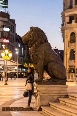 Skopje, Makedonya - 24 Ekim 2015: Genç kadın witing altında bir aslan heykeli, Üsküp 2014 projesinin bir parçası. 2012 yılında açıldı, şehrin yerlerinden biri oldu