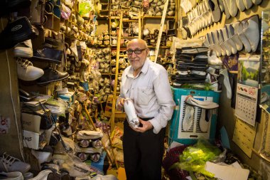 Isfahan, Iran - 8 Ağustos 2015: onun ayakkabı için gösterilen eski İran kunduracı satmak onun mağazasında şehrin ana yerlerinden biridir kaplı Isfahan Çarşı Pazar