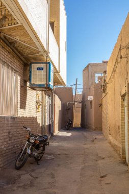 Yazd, Iran - 9 Ağustos 2018: eski şehir Yezd, iran, onun tipik kil duvarlar ve binalar ile tipik bir sokakta duran iki motorcycyles. Yazd olduğunu ana şehir merkezi iran, müzikbüyük turistik yerler