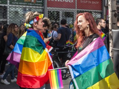 Belgrade, Sırbistan - 16 Eylül 2018: İki kız ve eşcinsel sarılmış ve giymiş gökkuşağı bayrakları Belgrad Gay Pride sırasında kalabalığın ortasında resmi. Tören bu yıl sorun olmadan oldu