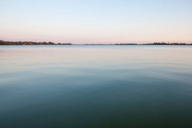 Mavi suları Palic Gölü, Subotica, Sırbistan, bir yeşil çim olarak da bilinen Palicko Jezero, bir yaz gün batımı sırasında arka planda bir Vojvodina il ana konumlar olduğunu