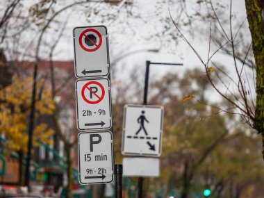 Tipik Kuzey Amerika paking ve Montreal, Quebec, Kanada, yaya geçidi arka planda gösteren bir işaret ile çekilen Park mevzuatı hakkında ayrıntılı talimatlar ile hiçbir Park işaretleri