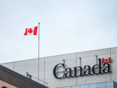 Ottawa, Kanada - 10 Kasım 2018: Kanada Wordmark, feragat Kanada bayrağı yanındaki bir idari binasında Kanada hükümetinin resmi logosu