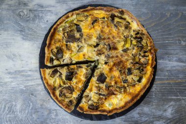 Fransız sebze Quiche Lorraine turtayla kesim, yukarıdan, rustik ahşap bir masa ekranda görüldü. Doğu Fransa, bir pasta börek, peynir, süt, krema ve sebze yapılan ikonik bir yemektir