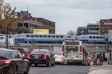 Montreal, Kanada-9 Kasım 2018: St Laurent Bulvarı 'nda araba ve otobüs ile trafik sıkışıklığı allo Exo Montreal bir banliyö treni sokakta bir demiryolu köprüsü üzerinde geçerken