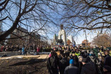 Ottawa, Kanada - 11 Kasım 2018: Ulusal Savaş anıtında, arka planda parlamentoyla, çatışmalarda ölen Kanadalıları anmak için anma gününde kalabalık toplanıyor