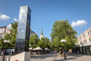 Indija, Sırbistan - 20 Mayıs 2018: İnciya ana yaya caddesi, Ulica Voyvode Stepe, bir chuche, bir saat kulesi, ağaçlar ve kafeler görünür. Indija Voivodina ve Srem İlçesi ana ciites biridir