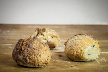 Rustik ahşap bir masa, baget tarzı ekranda Fransız ekmek üç küçük somun. Onlar Fransız petits ağrıları denir, levain denilen maya yapılmış