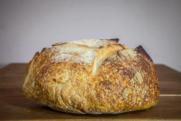 木製のテーブルに展示されたフランスのサワー生地のローフ またはマイク と呼ばれるペイン カンパーニュ ペイン カンパーニュは 伝統的なコードに従う典型的なフランスの巨大なパンです — ストック写真