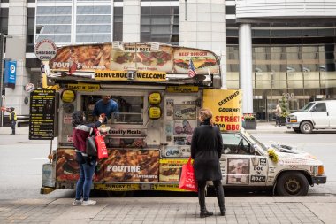 Toronto, Kanada - 13 Kasım 2018: Downtown Toronto, Ontario'da yemek siparişi veren, Cbd yakınlarındaki bir sokakta hamburger, patates kızartması ve somurtma satan geleneksel Kuzey Amerika yemek kamyonu