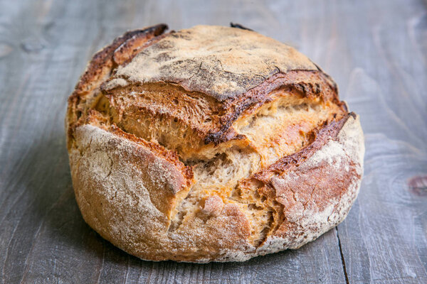 Loaf (or miche) of French sourdough, called as well as Pain de campagne, on display on a wooden table. Pain de Campagne is a typical French huge loaf of bread abiding by the traditional code