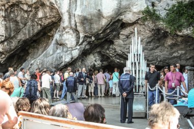 Lourdes, Fransa - 22 Ağustos 2006: Kutsal Meryem hayaletinin gerçekleştiği söylenen Notre Dame de Lourdes sancutuary'deki Grotte de Massebielle mağarasına girmek için bekleyen hacı ların kalabalığı