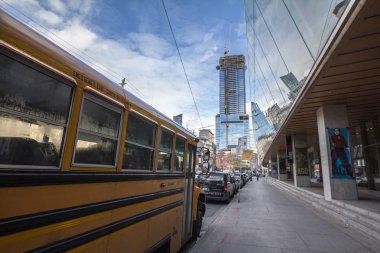 Toronto, Kanada - 14 Kasım 2018: Kuzey Amerika Sarı Okul Otobüsü, Toronto şehir merkezinde vinçlerle bir kınamak gökdeleninin şantiyesinin önünde duruyor