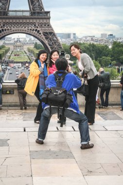 Paris, Fransa - Temmuz 21, 2011: Çinli turistler Eyfel Kulesi önünde fotoğraf çekmek. Tour Eiffel, Paris'in en önemli turistik yerlerinden biridir ve asyalı turistlerin sayısı giderek artar.