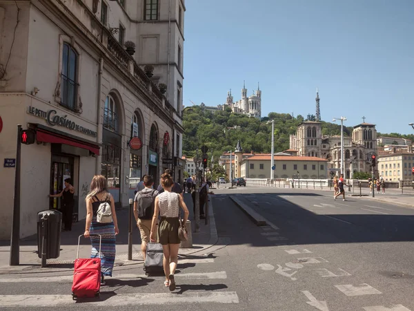 法国里昂 2019年7月19日 游客带着行李和手提箱在里昂市中心散步 背景是四维埃大教堂的标志性地标 — 图库照片