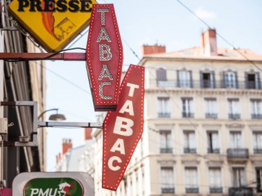 LYON, FRANCE - JULY 14, 2019: French tobacconist sign on a tobaccol seller, selling cigarettes. They are iconic of France, also called buraliste or marchand de tabac clipart