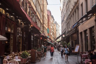 LYON, FRANCE - JULY 13, 2019: Tourists walking in Typical street of the Vieux Lyon (old Lyon) on the Presqu'ile district with tourists passing by near restaurants during a summer afternoon clipart