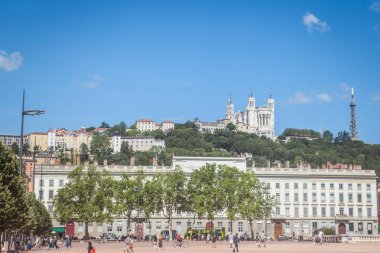 Lyon, Fransa - 14 Temmuz 2019: Basilique Notre Dame de Fourviere Kilisesi Place Bellecour meydanından görüldü. Bu iki yer Lyon'un önemli simgeleridir.