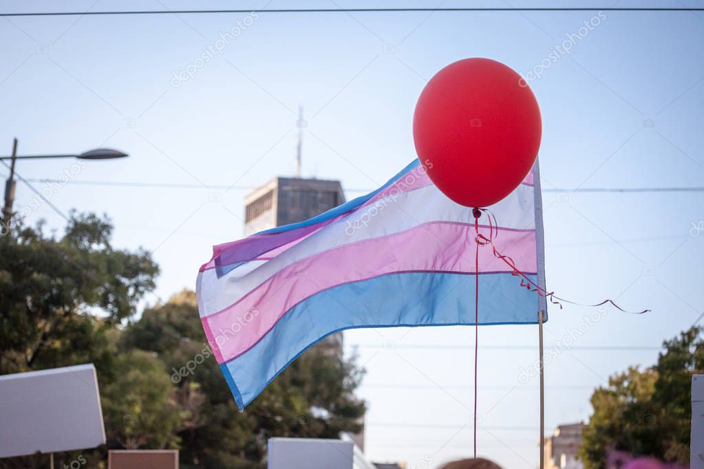 Transgender flag waiving in the air with a balloon during the Belgrade gay Pride in Serbia. This flag is an LGBTQ symbol for the transsexual community