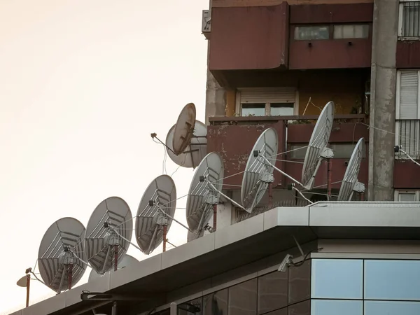 Satellitenschüsseln Und Antennen Auf Dem Dach Eines Geschäftshauses Bei Sonnenuntergang — Stockfoto