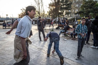 Belgrad, Sırbistan - 2 Nisan 2016: Başta Suriyeli ve Afganistan 'lı erkekler olmak üzere mülteciler, Belgrad' daki bir parkta dinlenip oynuyorlar ve Avrupa Birliği 'ne doğru yol alıyorlar