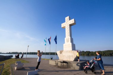 VUKOVAR, CROATIA - 11 Mayıs 2018: Beyaz Haç önünde fotoğraf çeken insanlar, veya katolik kilisesinden 1991 Sırbistan 'daki Hırvatistan ihtilafı sırasında hayatını kaybeden insanlara anıt olan Bijeli Spomen Kriz