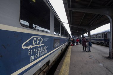 BÜKREŞ, ROMANIA - 15 Şubat 2020: CFR Calatori logosu Bükreş 'in ana tren istasyonu Gara de Nord' daki şehirlerarası trenlerinden birinin önünde. CFR Calatori, Romen yolcu demiryolu şirketi.