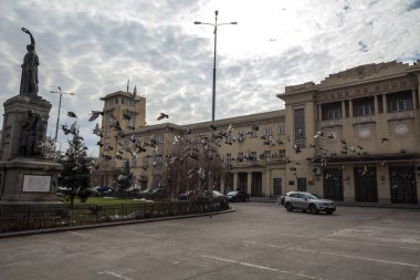 BÜKREŞ, ROMANIA - 15 Şubat 2020: Bükreş 'in ana tren istasyonu Gara de Nord' un üzerinde güvercinler uçuşurken ana cephesi. Gar de nord, Romanya 'nın ana tren istasyonu.