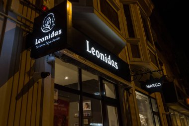 BRASOV, ROMANIA - 14 Şubat 2020: Leonidas Çikolatası 'nın logosu geceleyin yerel mağazalarının önünde. Leonidas, Avrupa 'ya yayılmış Belçikalı bir çikolata üreticisi ve perakendecisi.