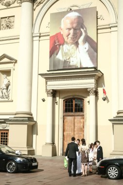 VARŞAN, POLAND - 12 HAZİRAN 2009: kilisenin önünde elinde John Paul II 'nin dev bir resmi olan yeni evli genç insanlar, ya da Polonya' da büyük ölçüde tapılan tek Polonyalı papa Karol Wojtyla,