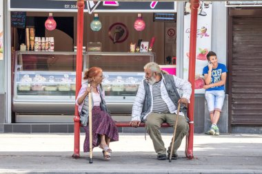 PANCEVO, SERBIA - 13 Haziran 2015: Pancevo 'nun merkezinde otobüs beklerken Roma toplumuna mensup üst düzey bir erkek ve bir kadın olmak üzere iki yaşlı kişi tartışıyor