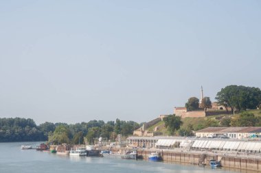 BELGRAD, SERBIA - 13 Ağustos 2018: Belgrad 'daki Sava nehir kıyısı manzarası. Tekneler ve balıkçılar önde, Kalemegdan kalesi ise arka planda ikonik Viktor ile görülebilir.