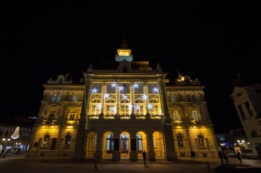 NOVI SAD, SERBIA - NOVEMBER 18, 2016: Trg Slobode Meydanı ile belediye binası, veya Gradska Kuca, Novi sad, Sırbistan 'ın ikinci büyük kenti, geceleri, insanlar geçerken