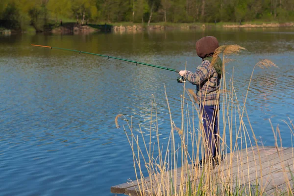 El chico con caña de pescar. Niño en spinning pesca . — Foto de Stock