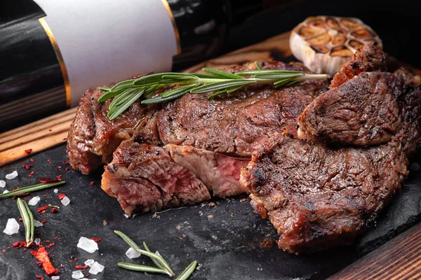 Bir taş ve bir şişe şarap ile bir gemide eti biftek orta — Stok fotoğraf