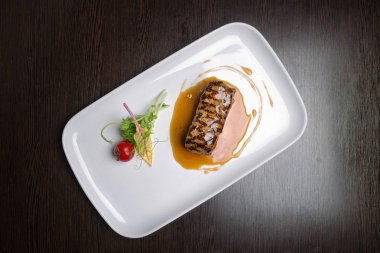 Sebzeli et biftek bir ahşap tahta üzerinde beyaz bir tabakta teriyaki sos. görünümü üst