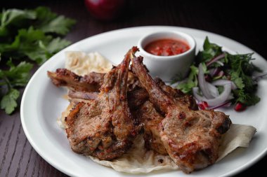 Sos ve soğan ile beyaz bir plaka üzerinde kızarmış kaburga