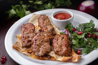 Beyaz bir plaka üzerinde şiş kebap