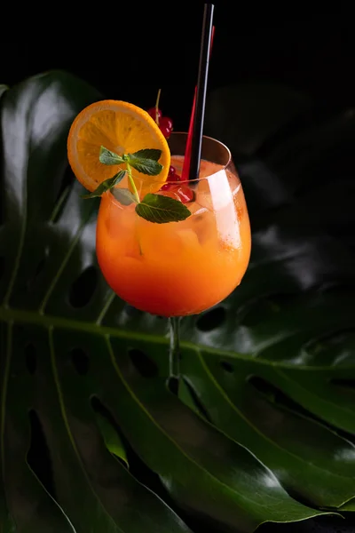 Tequila Sunrise cocktail, on a black background