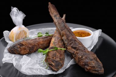 Siyah plaka üzerinde kızarmış balık, gobies