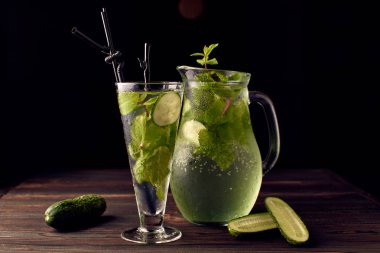 Limonata koyu bir arka plan üzerinde bir bardak bir salatalık