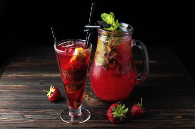 Limonata koyu bir arka plan üzerinde bir bardak bir çilek