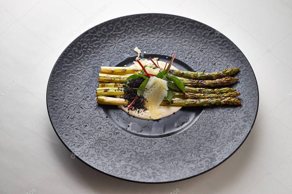 Asparagus with Parmesan on a black plate
