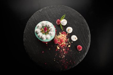 Siyah bir arka plan üzerinde ahududu ve fındık ile Cheesecake