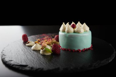 Siyah bir arka plan üzerinde ahududu ve fındık ile Cheesecake