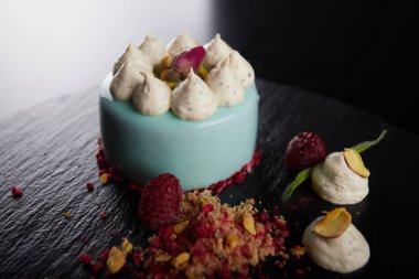 Siyah bir arka plan üzerinde ahududu ve fındık ile Cheesecake