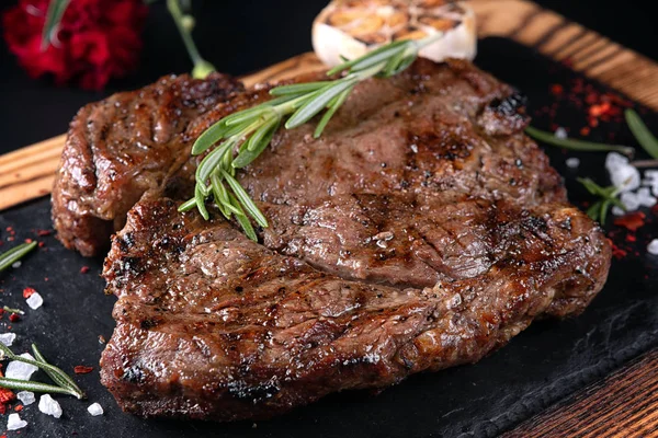 Smažený masový steak na břidlici na černém pozadí — Stock fotografie