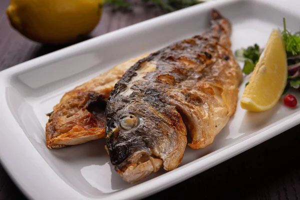 Жареная рыба Дорадо на белой тарелке — стоковое фото